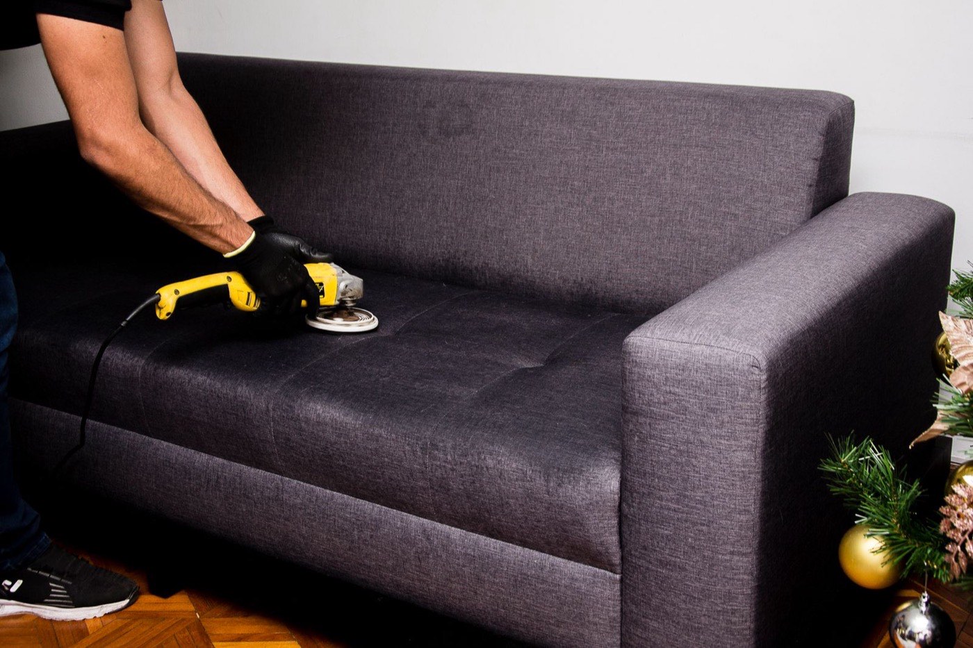 BluePeak Cleaning Co. technician professionally cleaning a fabric sofa
